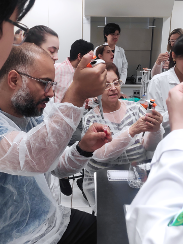 Um grupo de professores utilizando a micropipeta
